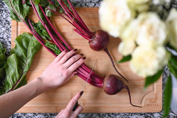 Can dogs eat beets: person chopping some beetroot stems